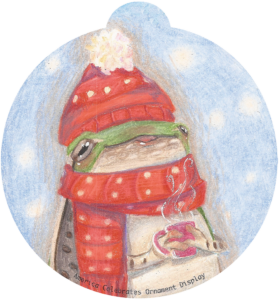 ornament depicting a frog in winter garb clutching a mug of hot beverage