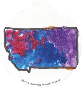 ornament depicting the outline of the state of Montana, filled in with sparkly blue, red, and purple glitter