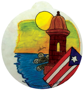 ornament depicting the Puerto Rico flag, a stone tower, and the ocean against a sunset