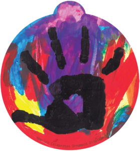 ornament with a collage of colors, on top a black handprint from a child